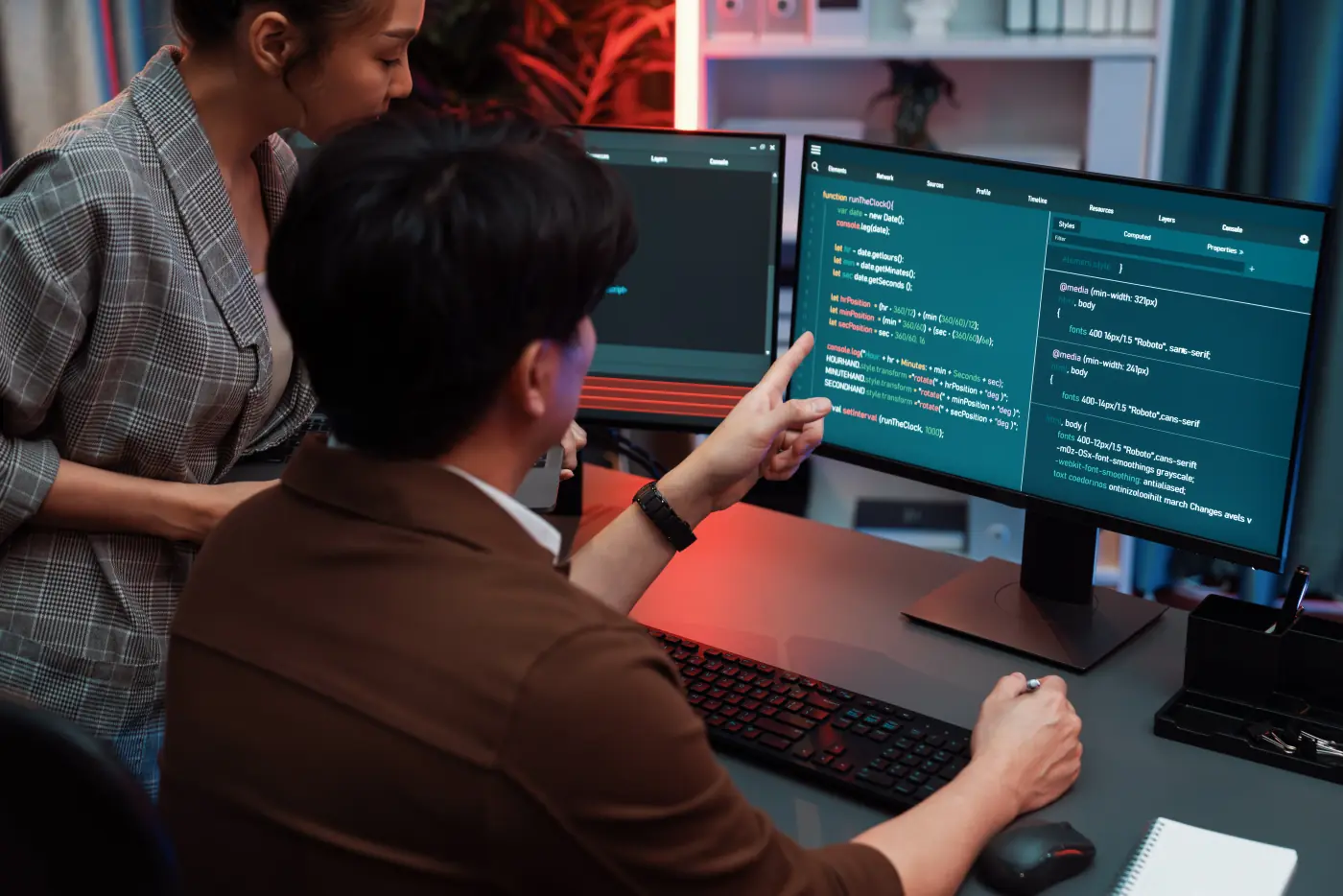 IT developers discussing with point website coding system